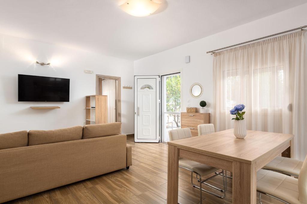 un soggiorno con divano e tavolo di Theros Luxury Apartment a Archangelos