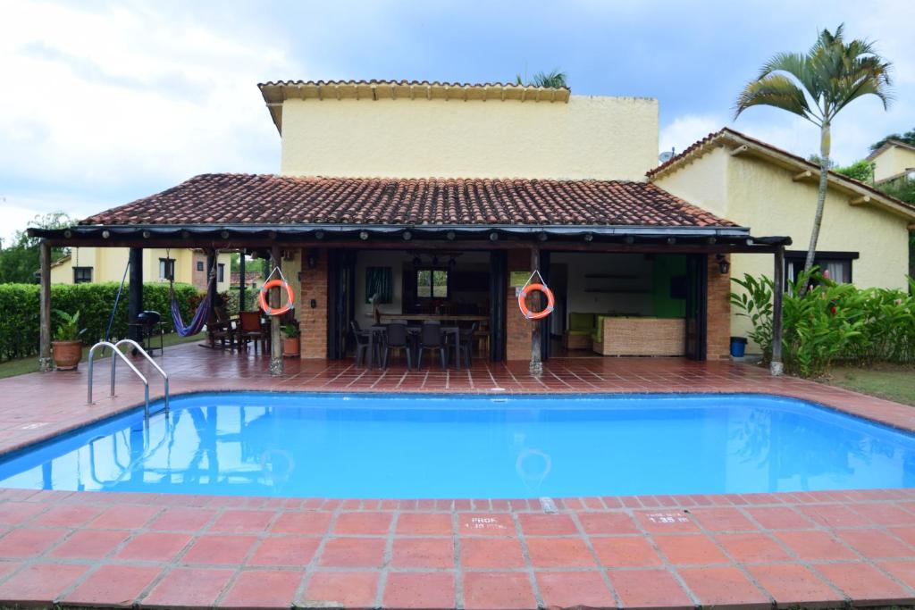 una casa con piscina frente a una casa en Fincas Panaca Herrería 4, en Quimbaya
