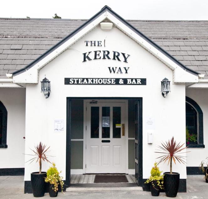 The Kerryway في Flesk Bridge: مبنى أبيض مع مطعم Kerry way يقدم اللحوم والبار
