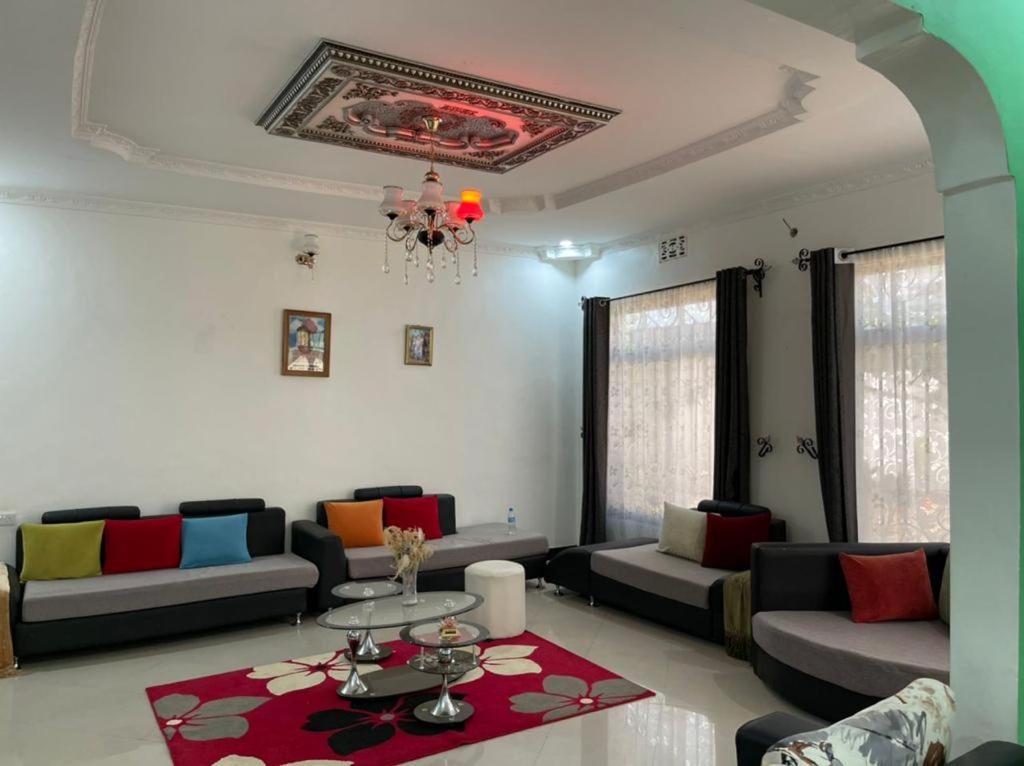 a living room with couches and a table at Evelina House in Boma la Ngombe