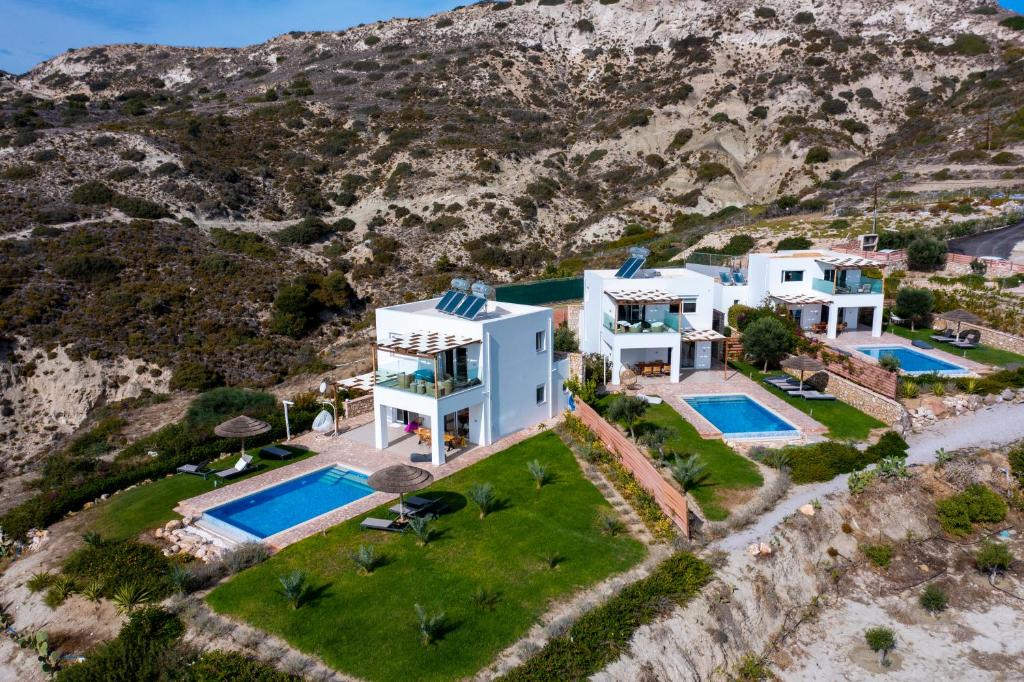 - une vue aérienne sur une villa avec 2 piscines dans l'établissement The Three Graces, à Antimácheia