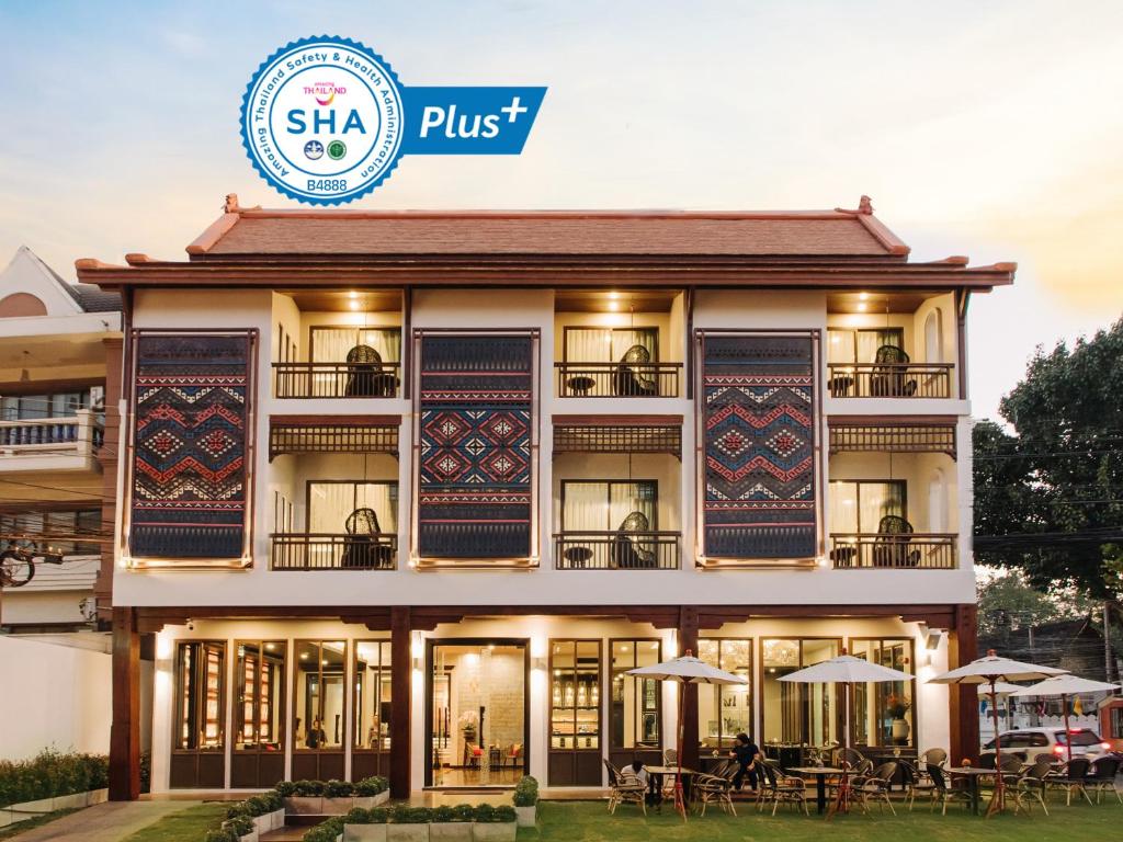 een gebouw met tafels en parasols ervoor bij T Heritage Hotel in Chiang Mai