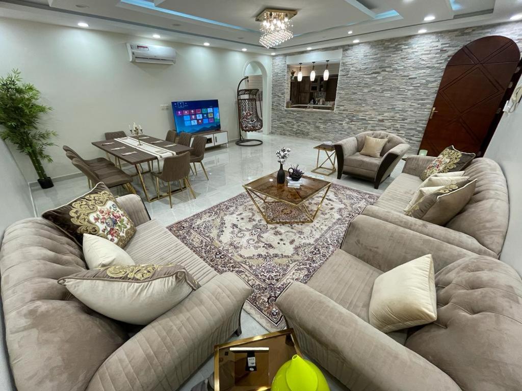 a living room with couches and a dining room at العلا بيتك in AlUla