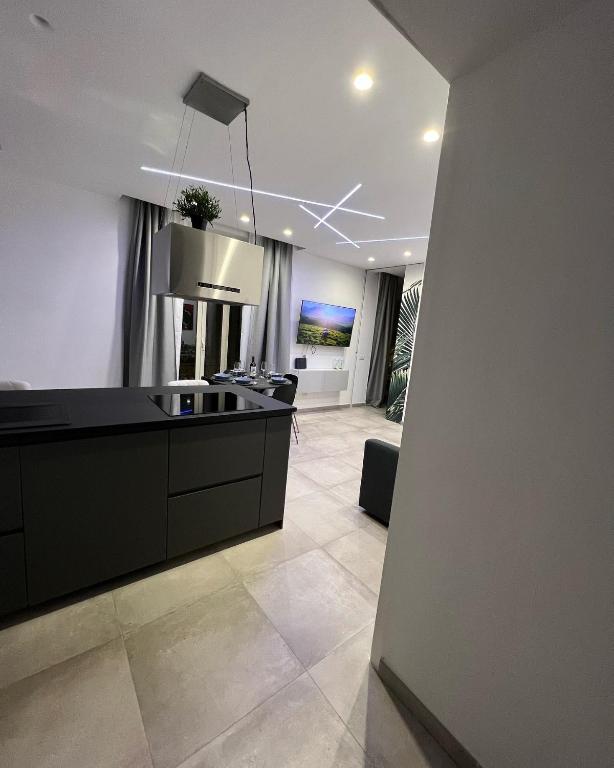 a kitchen with a black counter and a living room at The Jungle Home in Naples