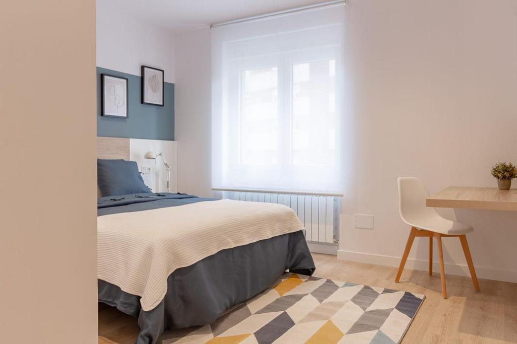 1 dormitorio con cama, escritorio y silla en Room4You Oviedo by Asturias Holidays en Oviedo