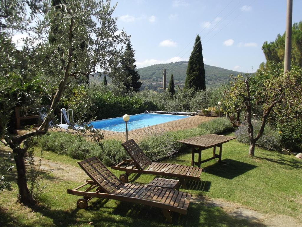 a picnic table and two chairs next to a pool at Casale Asciolo in Bagno a Ripoli