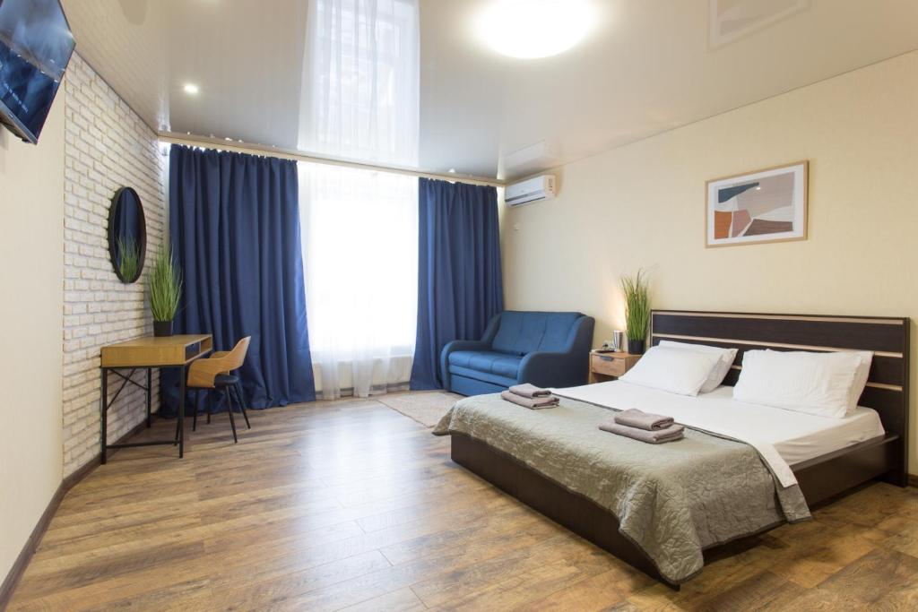a bedroom with a bed and a blue chair at Studio with an amazing view - 15th floor in Kharkiv
