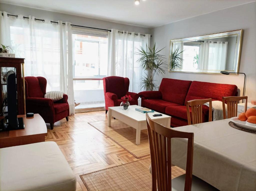 a living room with a red couch and a table at Casa Porto, con Garaje in Vigo