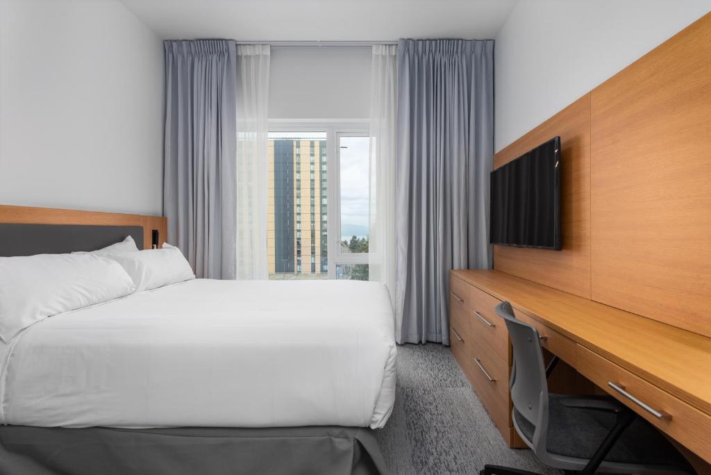 Säng eller sängar i ett rum på Gage Suites at UBC