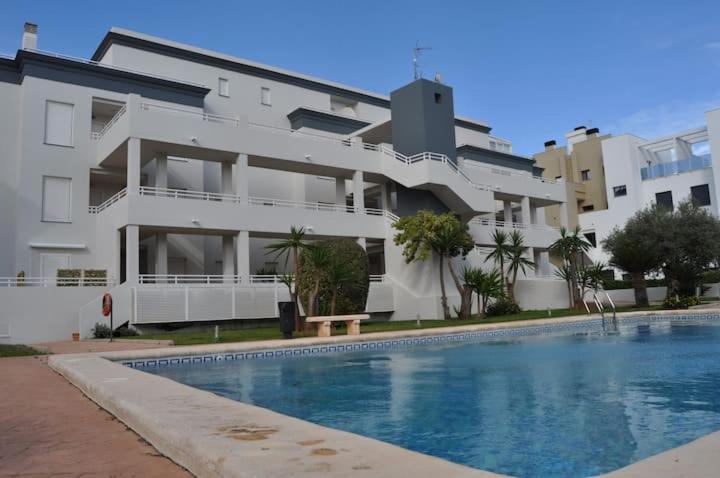 a building with a swimming pool in front of a building at MET&GOLF OLIVA NOVA BEACH JARDIN in Oliva