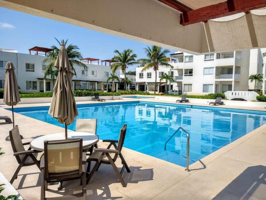 a swimming pool with a table and chairs next to a building at Villa&Roofgarden -Jacuzzi privado- Relax&Confort in Acapulco