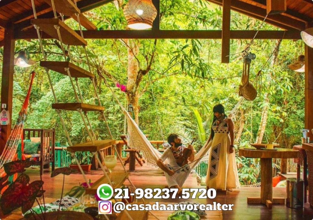 a man and a woman sitting in a hammock at CASA DA ARVORE, sonho na Amazônia, 2min a pé da praia in Alter do Chao