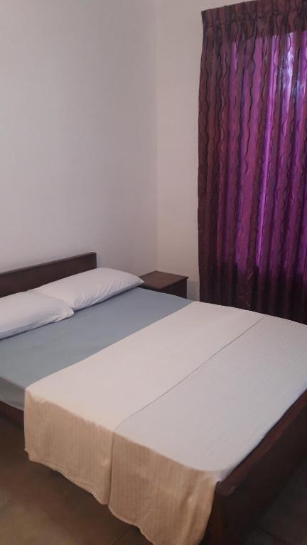 duas camas num quarto com uma cortina roxa em The View at Glenloch - Home Stay em Tawalantenna
