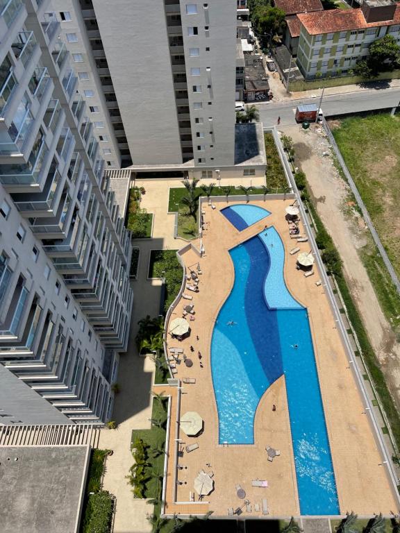 - une vue aérienne sur une piscine au milieu d'un bâtiment dans l'établissement Lazer de resort a poucos passos da praia, à Guarujá