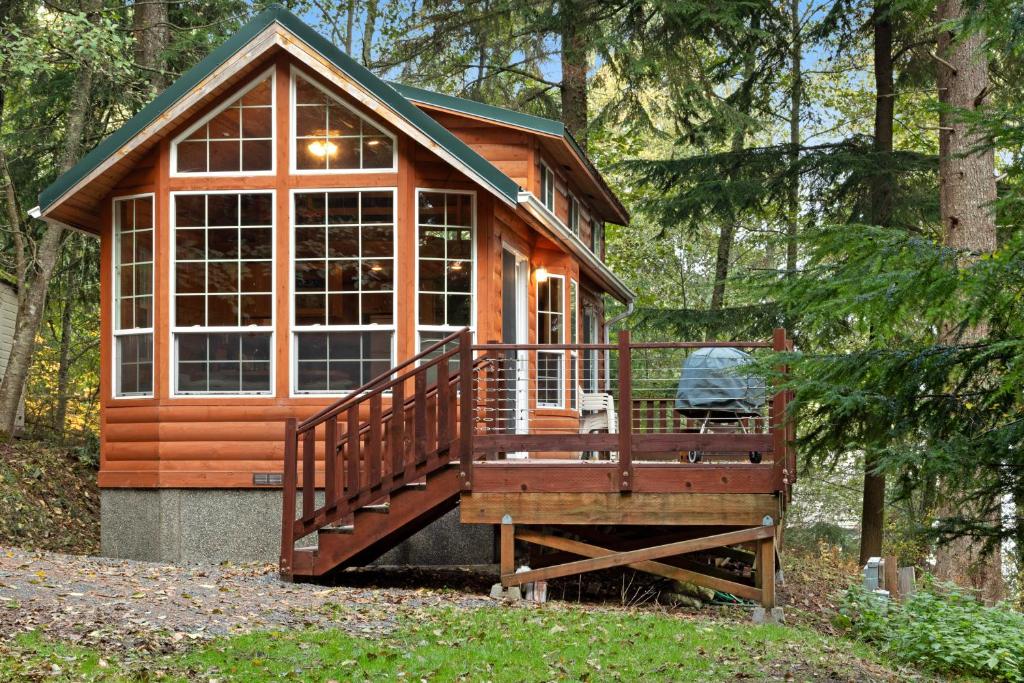 a small cabin in the woods with a large window at Racoon Retreat in Eastsound