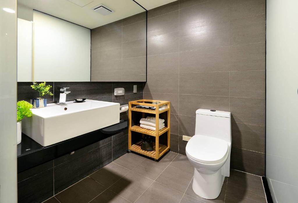 a bathroom with a white sink and a toilet at Beacon Hotel in Taichung
