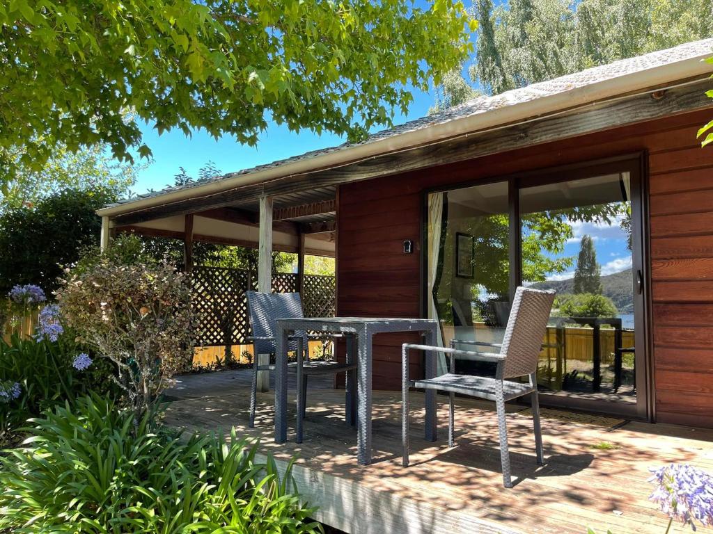 eine Terrasse mit einem Tisch und Stühlen auf einem Haus in der Unterkunft Motuoapa Bay Chalets in Turangi