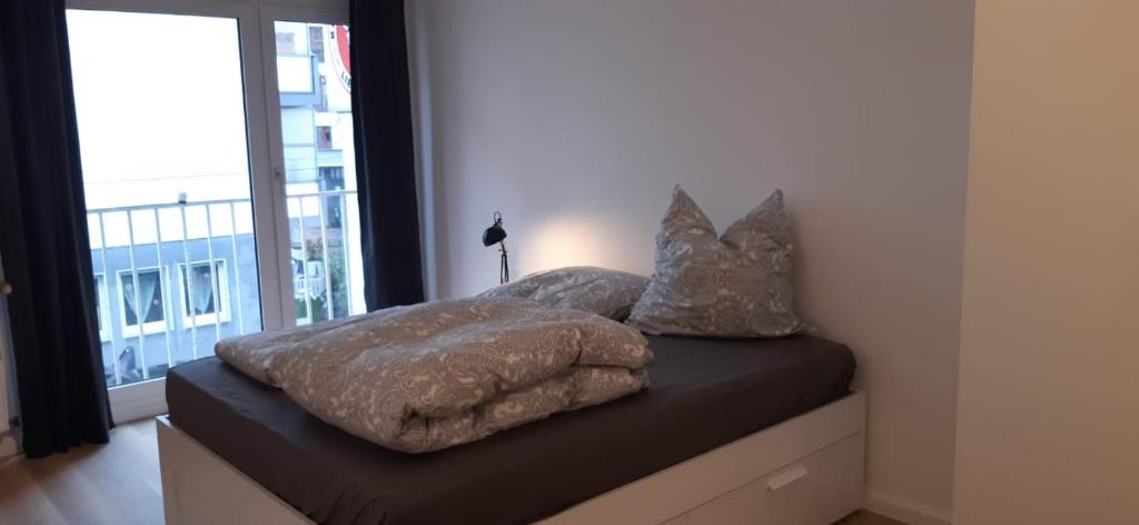 1 cama con 2 mantas y almohadas en Cozy City Apartment, en Düsseldorf