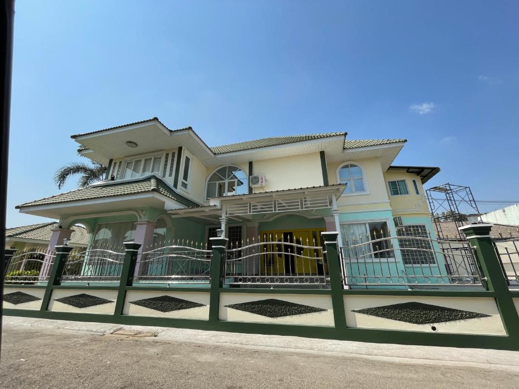 une grande maison avec une clôture devant elle dans l'établissement minimal house phichit, à Phichit
