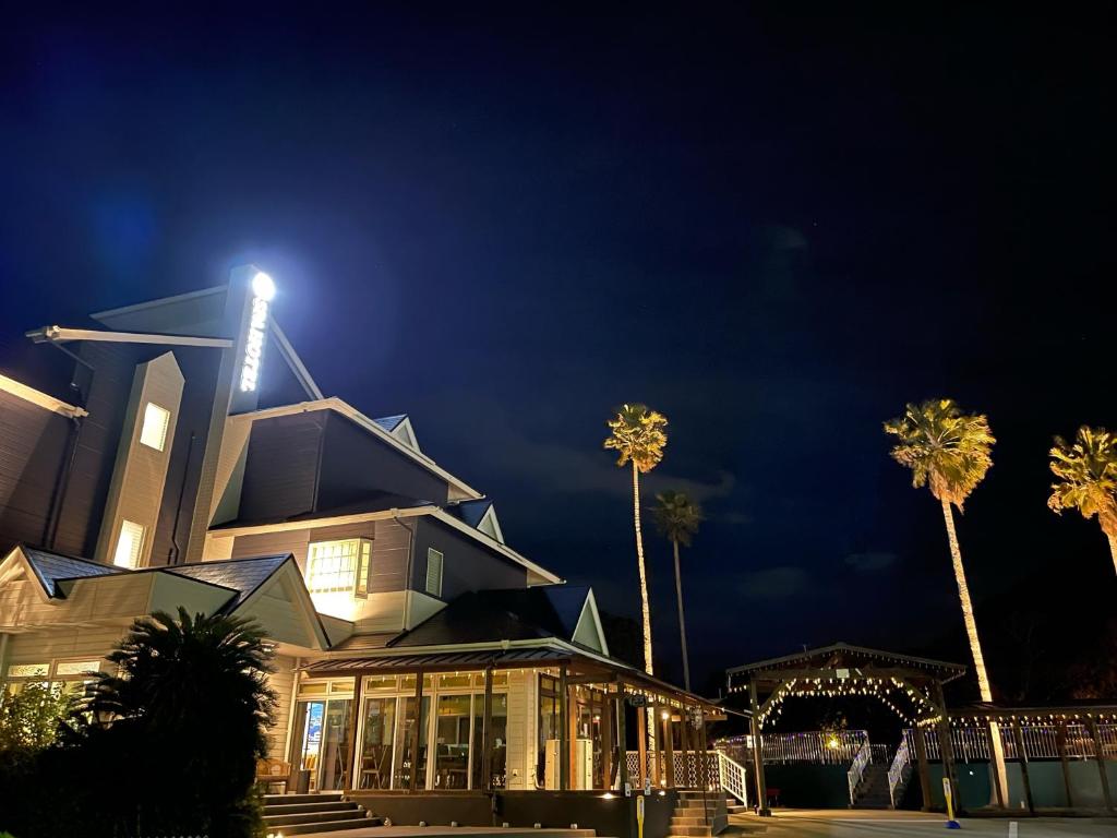 a building with palm trees in front of it at night at Alaise De Bale Shirahama in Shirahama