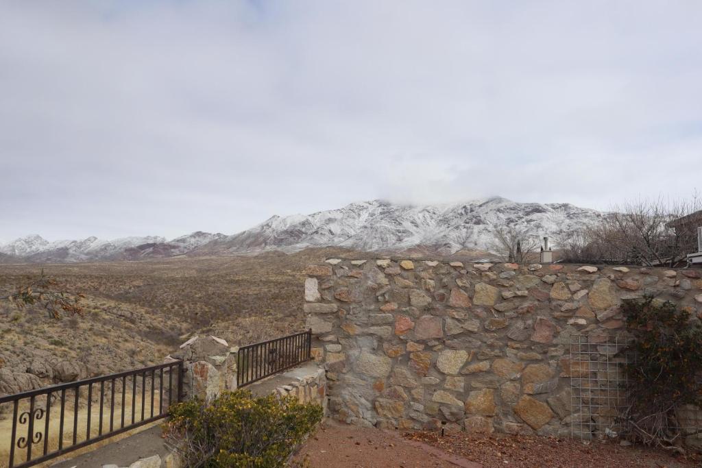 eine Steinmauer mit einem schneebedeckten Berg im Hintergrund in der Unterkunft Villa De Montana in El Paso