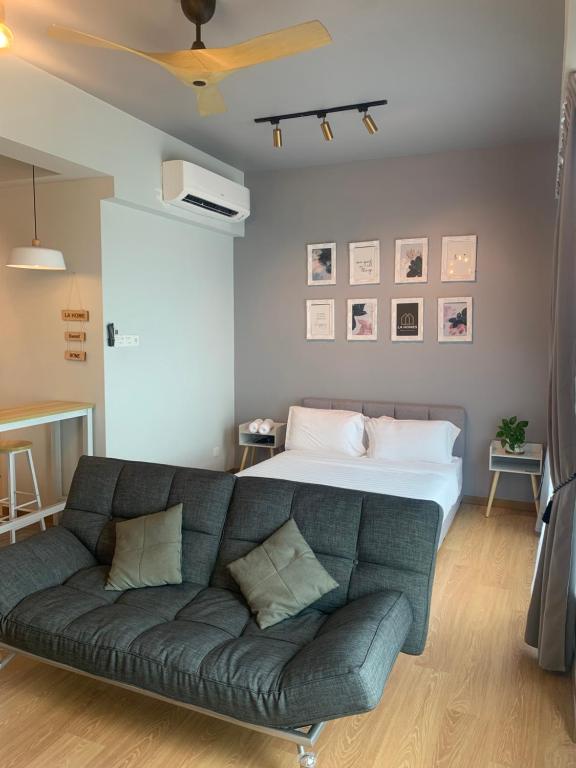 uma sala de estar com um sofá e uma cama em Imperium residence (LA HOMES) em Kuantan