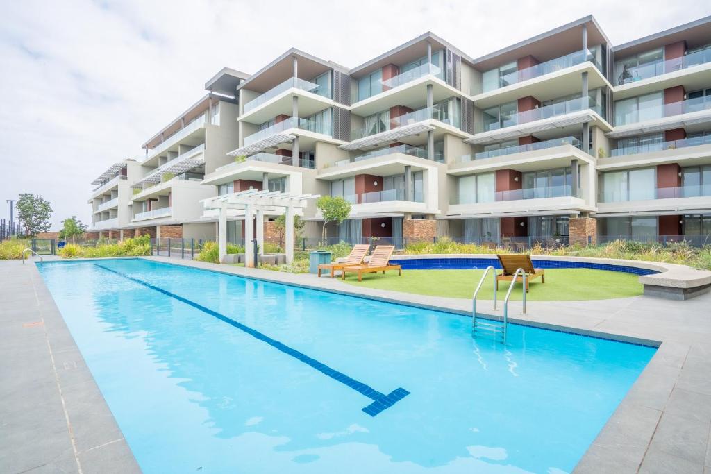 a swimming pool in front of a building at Unit 215 Oceandune - Stunning & Modern Apartment in Sibaya