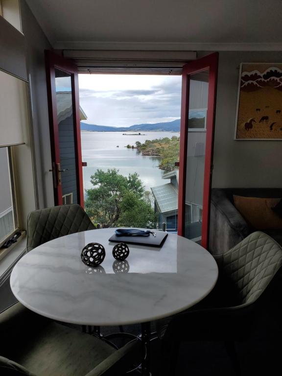 a table in a room with a view of the water at Lakeside Studio in Jindabyne