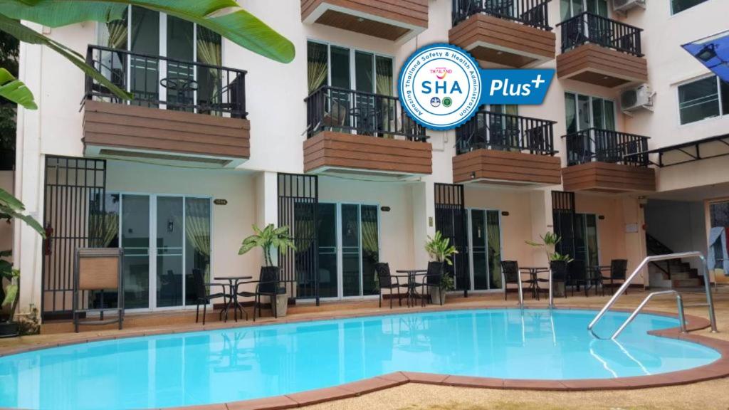 un hotel con piscina frente a un edificio en Manee Cool Mueang, en Chiang Mai