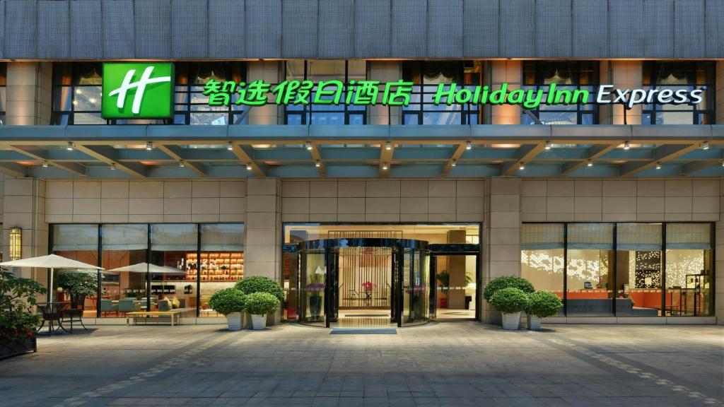 a building with a sign on the front of it at Holiday Inn Express Chengdu Huanhuaxi by IHG-Near Jinsha Site Musem,Near Wuhou Temple Museum,Welcome drinks,Free gym,Free self-service laundry in Chengdu