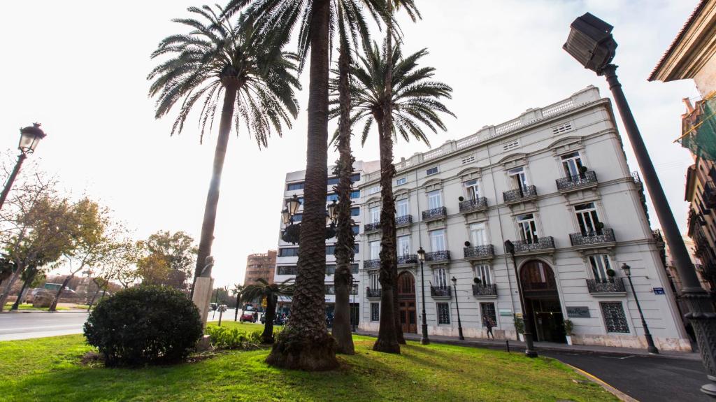 a large palm tree in front of a large building at The River Hostel in Valencia