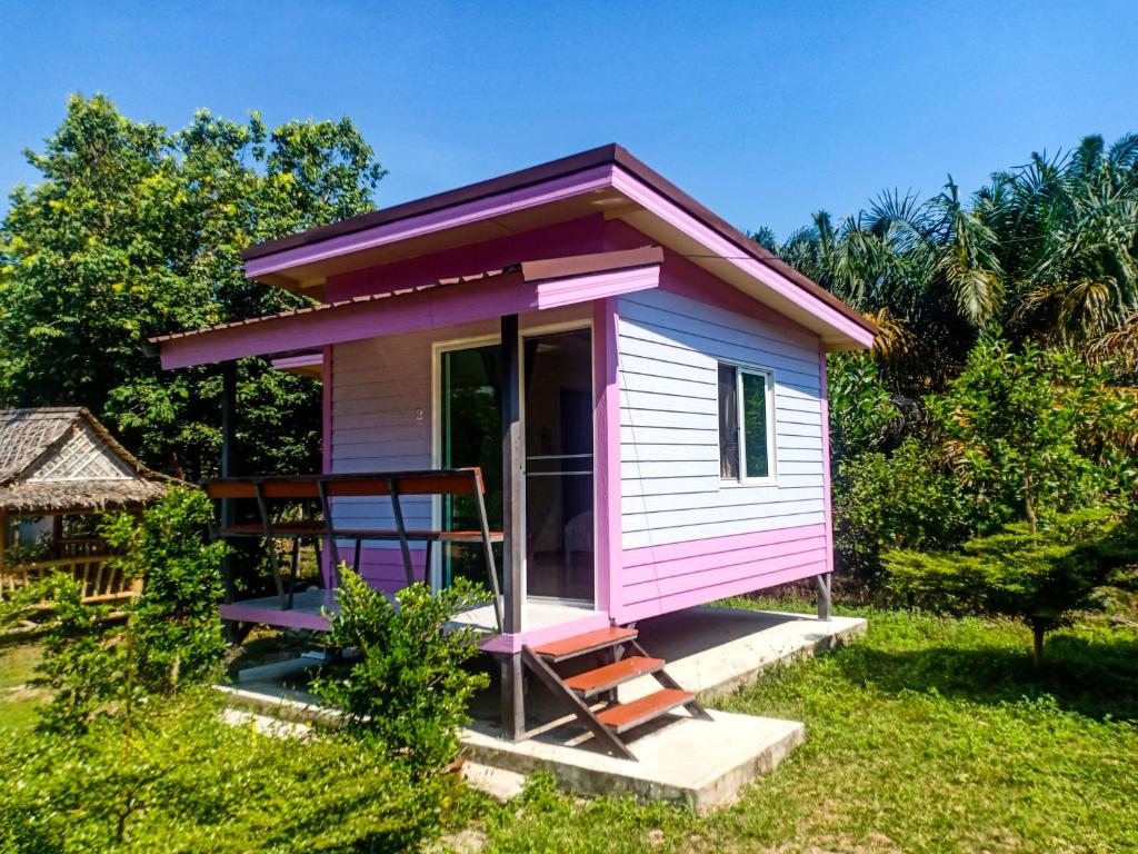 a pink tiny house with a porch at Win Gray Homestay Resort in Pathiu