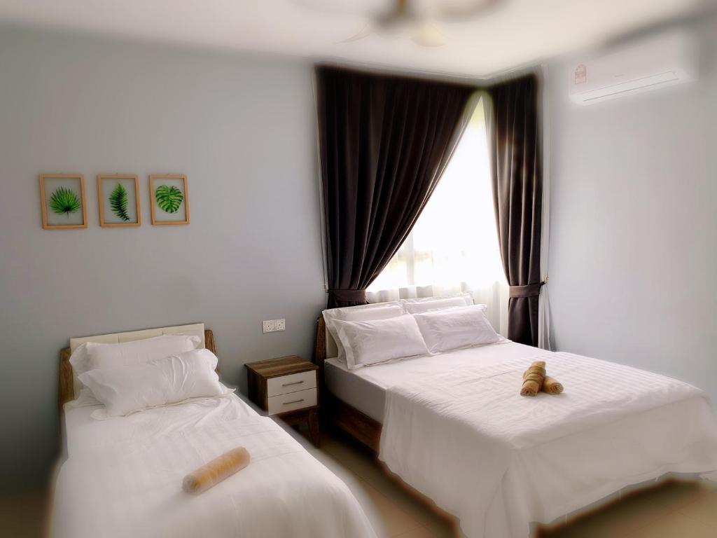 怡保的住宿－Aries Homestay，两间位于酒店客房的床,上面有两只泰迪熊