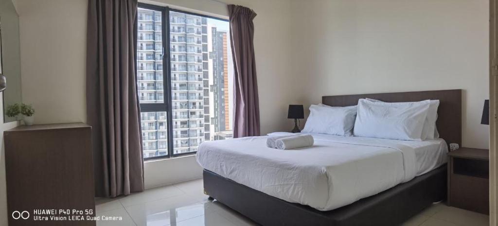 a bedroom with a large bed and a large window at Pool view + water theme park @swiss garden residence in Kuantan