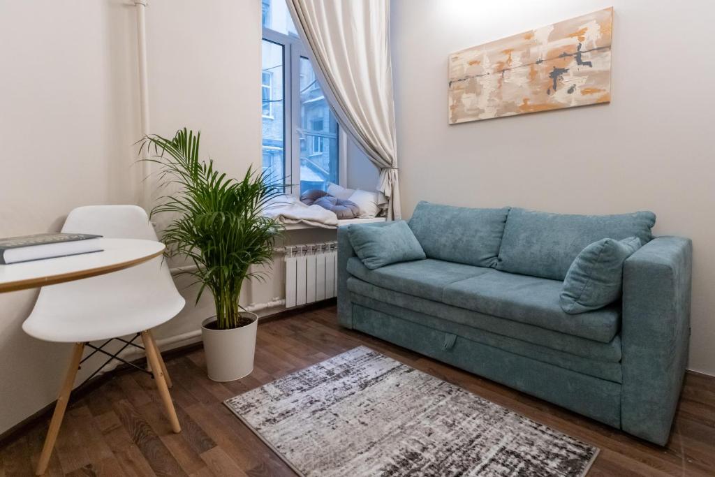 ein Wohnzimmer mit einem Sofa und einem Baby in einem Kinderbett in der Unterkunft Sonya studios in Sankt Petersburg