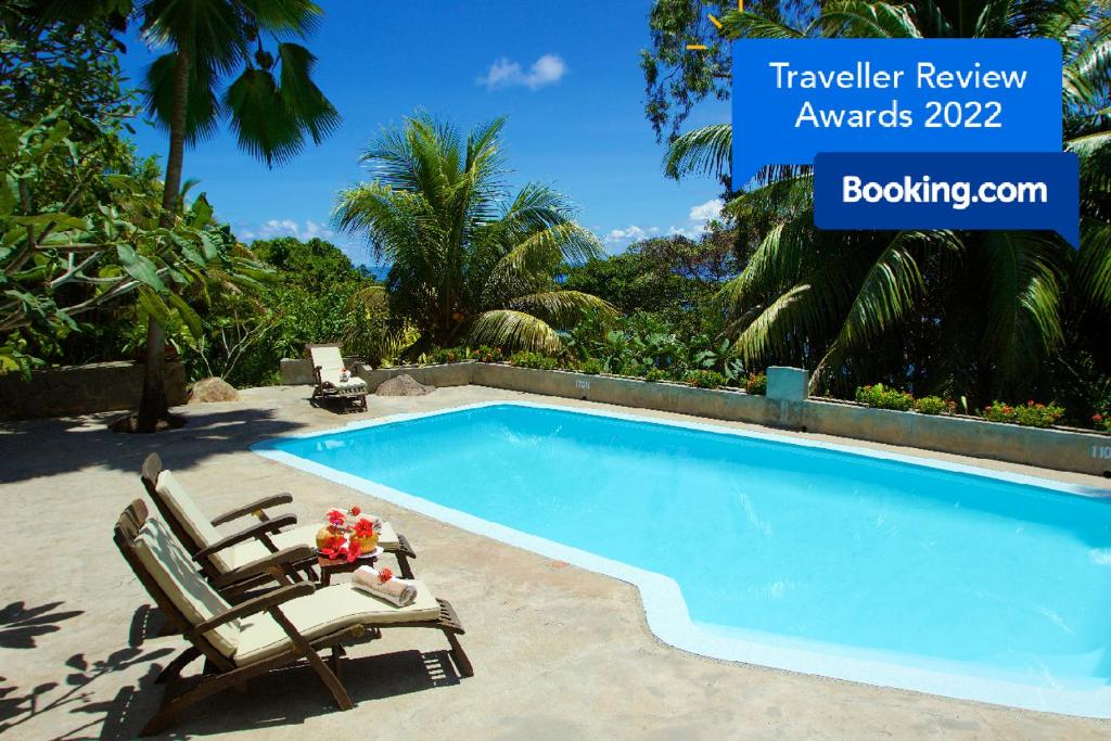 a swimming pool with two lounge chairs next to it at Hillcrest Villas in Glacis