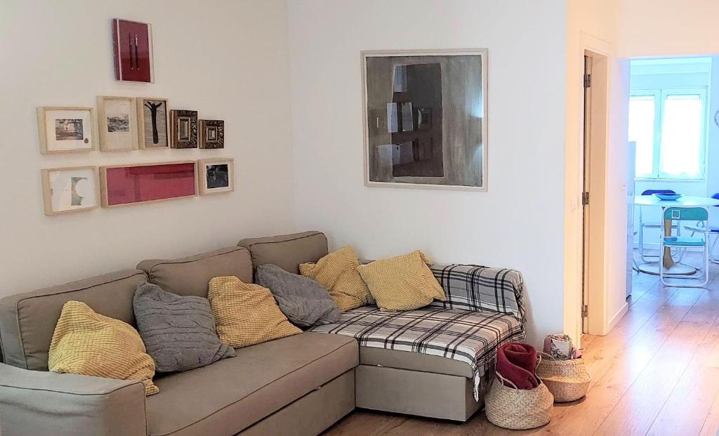 a living room with a couch with pillows on it at Alegramente in Lisbon