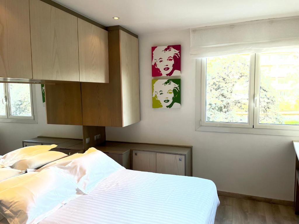 une chambre avec un lit et deux fenêtres dans l'établissement Chambre idéalement située à 50m de la Croisette, à Cannes