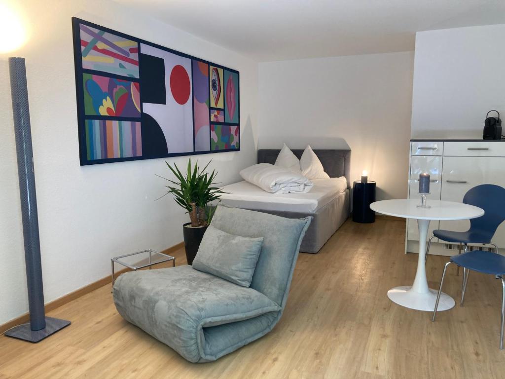 a bedroom with a bed and a chair and a table at Furnished studio with garden Seefeld I Tiefenbrunnen in Zurich