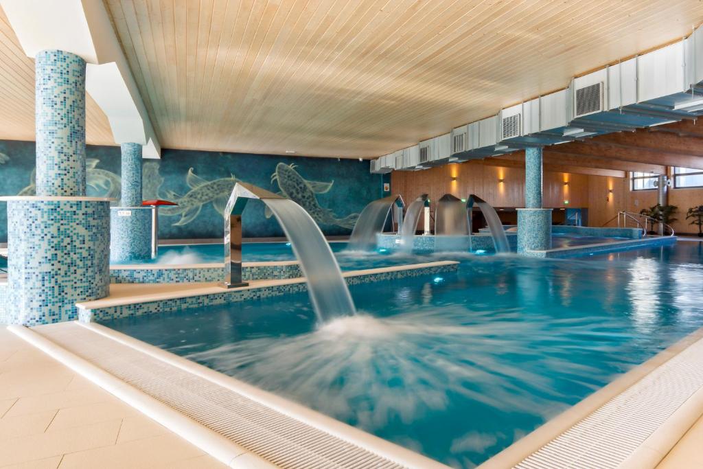 a swimming pool with water fountains in a building at River Style Hotel & SPA in Reda