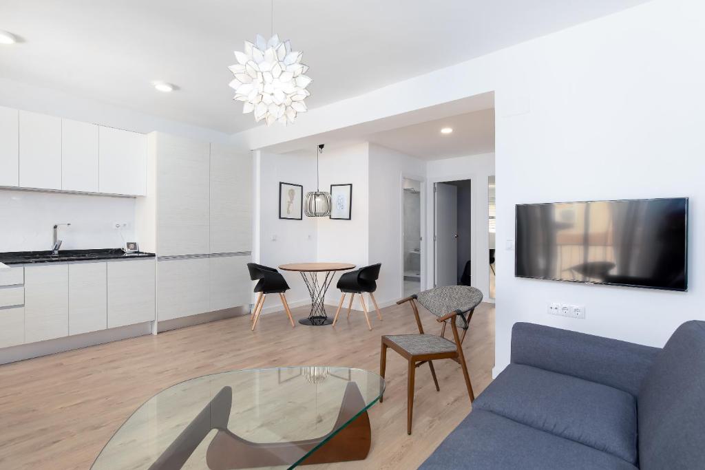 a living room with a blue couch and a table at ApartUP Port Area I in Valencia