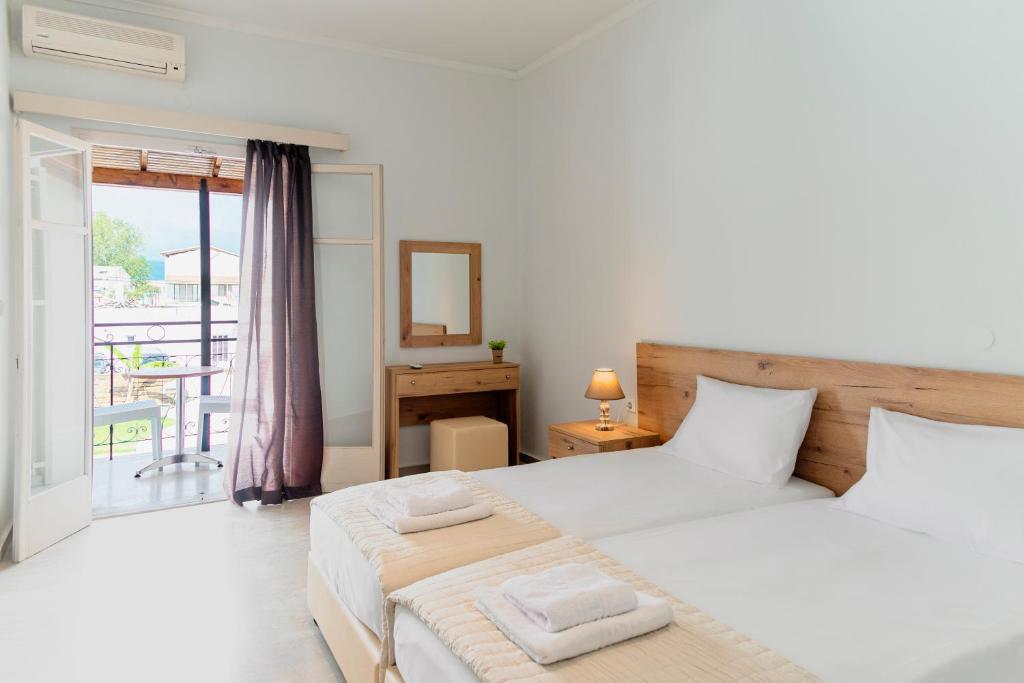 a bedroom with two beds and a balcony at Secreta Vista in Kavos