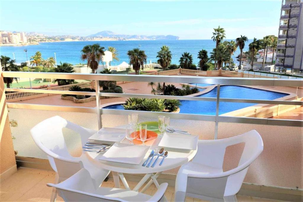 een tafel en stoelen op een balkon met uitzicht op de oceaan bij 1B Mar II 1 dormitorio con vistas al mar in Calpe