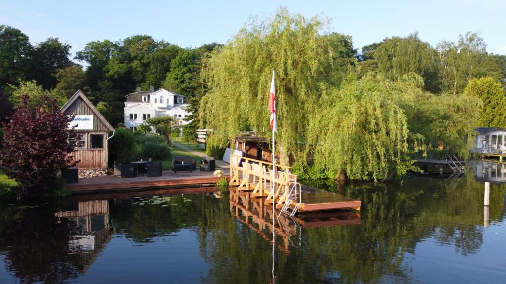 a dock with a sail boat on the water at Pension Seeschlösschen in Mölln
