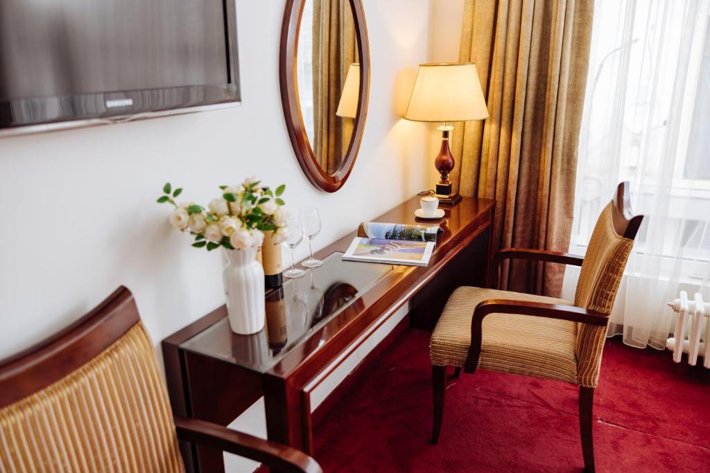 una camera d'albergo con scrivania e specchio di Garni Hotel Planeta Inn a Novi Sad