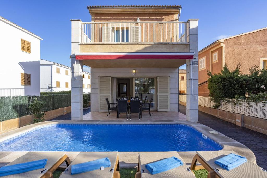 a swimming pool in a backyard with a house at Villa Playera in Alcudia
