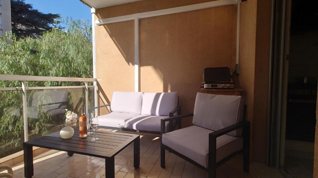 un patio avec deux chaises et une table sur un balcon dans l'établissement Magnifique appartement à 10mn du Palais, à Cannes