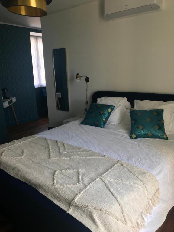 a white bed with a blanket on it with pillows at Chambres d'hôtes L'âme de Travassac in Donzenac