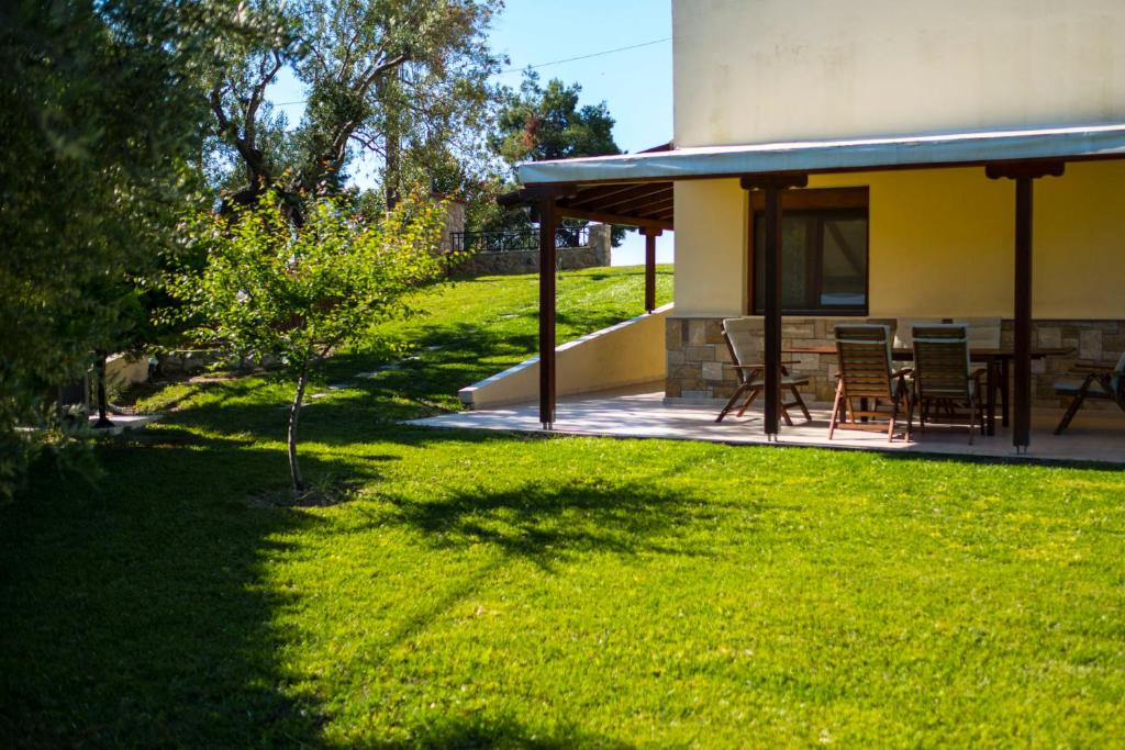 a house with a patio and a grass yard at Possidi Villas by Halkidiki Villas in Possidi