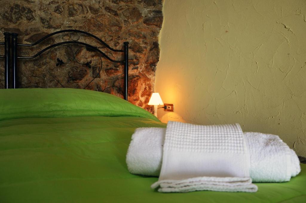 a bedroom with a green bed with white towels on it at Il Castello in Viggiano